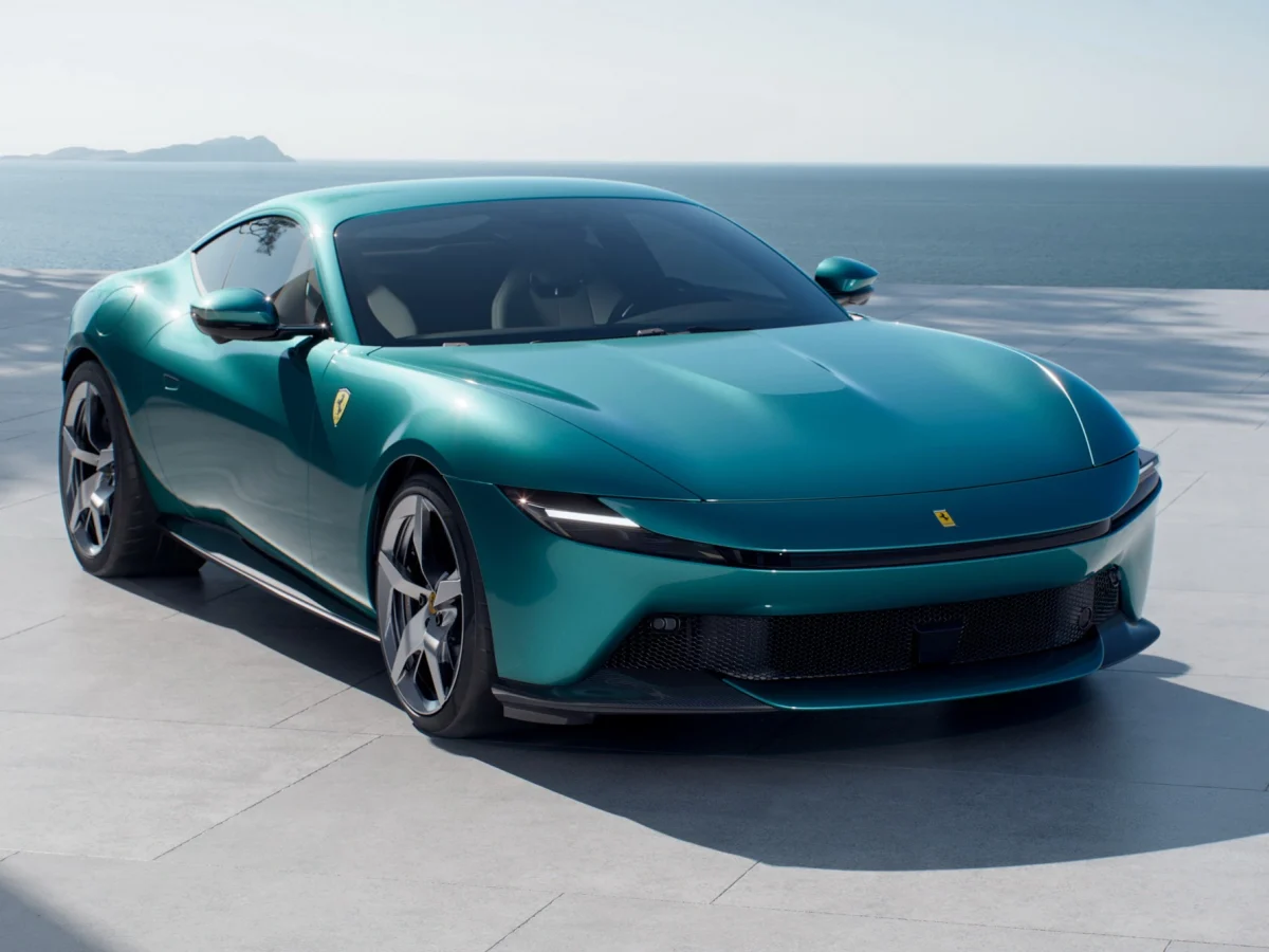 Елегантна Ferrari Amalfi 2026, вигляд спереду у три чверті на фоні середземноморського узбережжя.