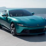 Елегантна Ferrari Amalfi 2026, вигляд спереду у три чверті на фоні середземноморського узбережжя.